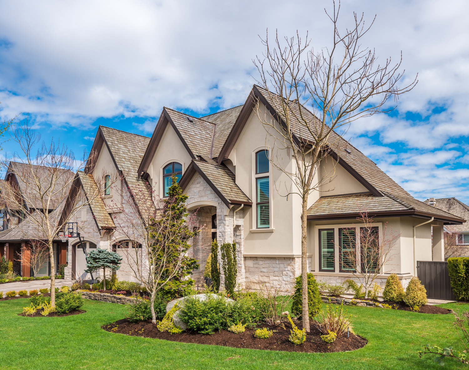 Beautiful exterior of newly built luxury home. Yard with green grass and walkway lead to front entrance.